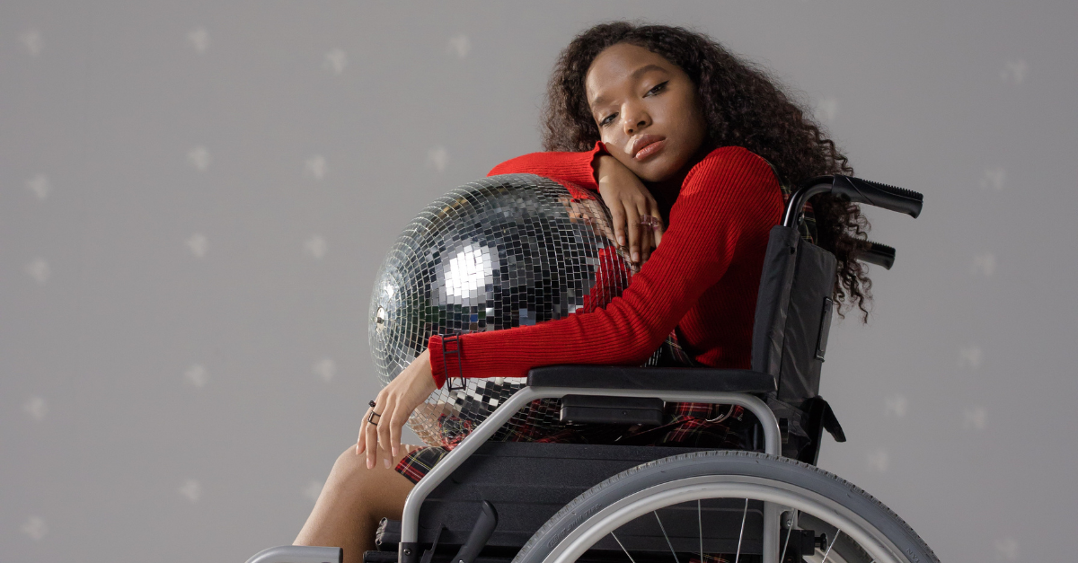 Girl Sitting in a Wheelchair with a Disco Ball