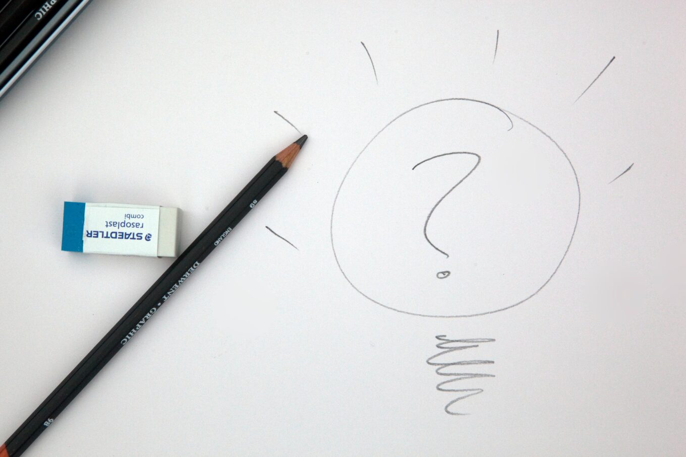 A notepad sketch of a lightbulb with a question mark inside of the bulb
