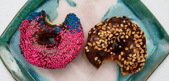 Two half eaten donuts on a plate