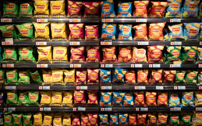 Packets of crisps shown shown on supermarket shelves